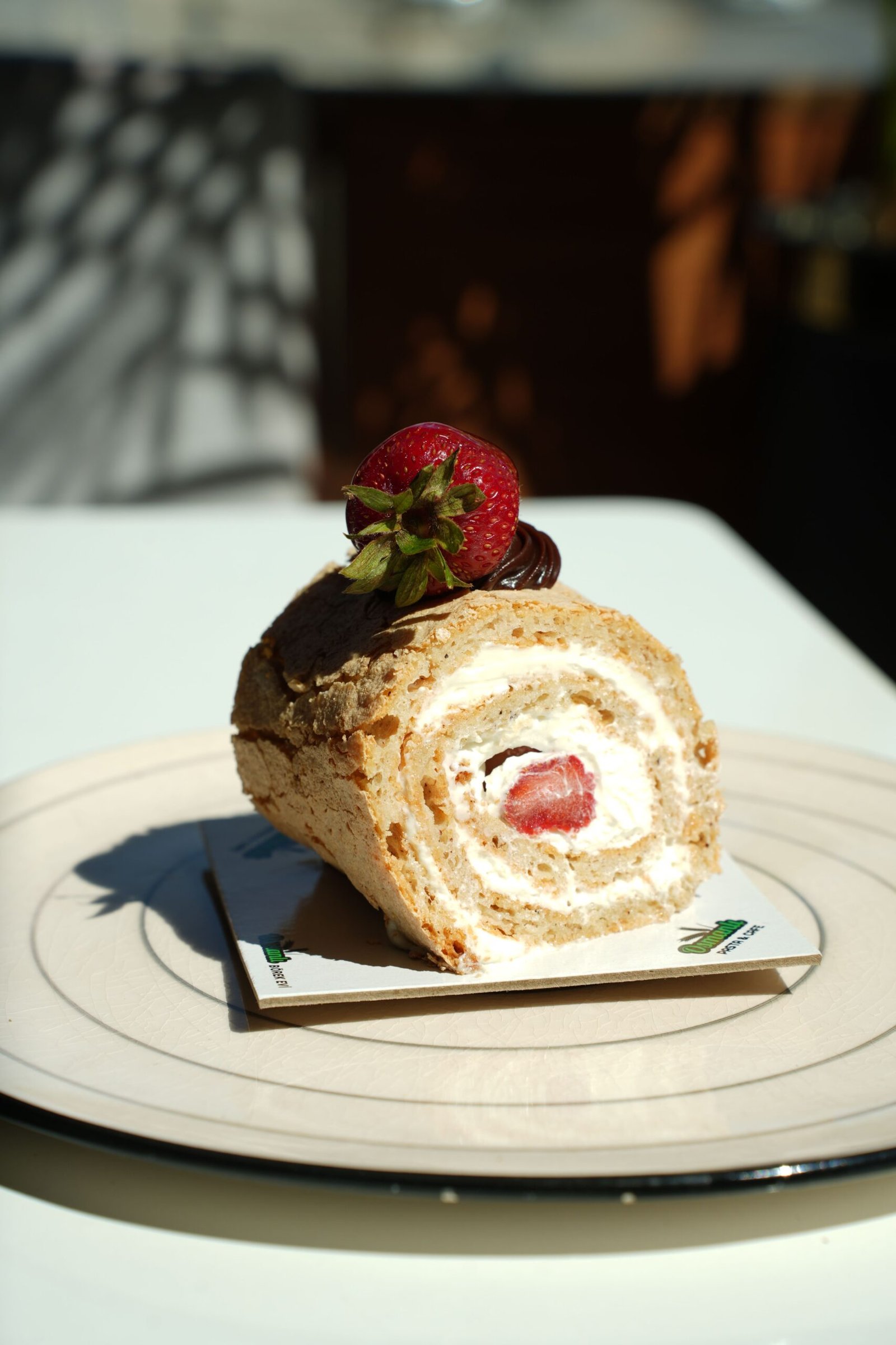 Strawberry Swiss Roll Cake: A Light and Elegant Berry Dessert Strawberry Swiss roll cake filled with whipped cream and fresh strawberries, topped with chocolate and a whole strawberry.