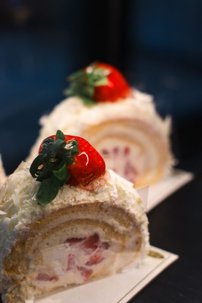 Strawberry Swiss Roll Cake: A Light and Elegant Berry Dessert Strawberry Swiss roll cake filled with whipped cream and strawberry pieces, topped with fresh strawberries and white chocolate shavings.
