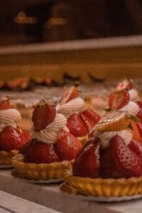 Strawberry tartlets dusted with powdered sugar and cream filling