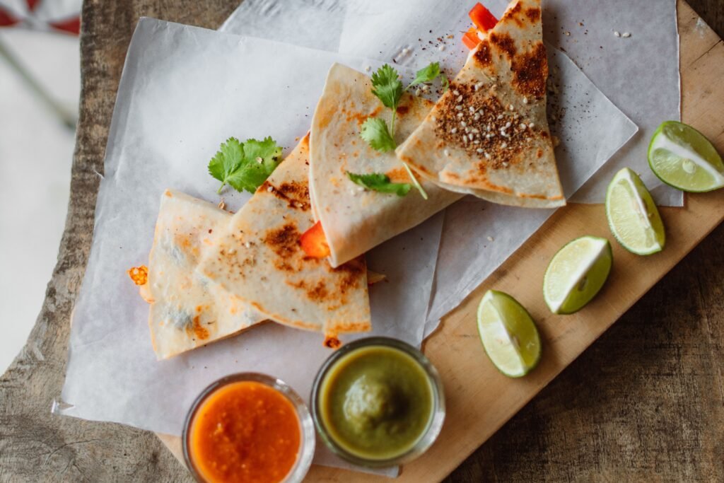 Easy Breakfast Quesadilla Recipe for a Quick Morning Meal Crispy breakfast quesadillas served with cilantro, lime wedges, red salsa, and green dipping sauce